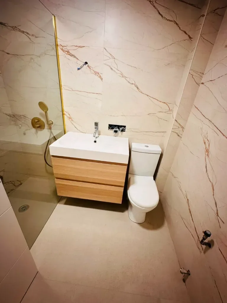 Ducha de obra en acabado mármol con grifería en dorado