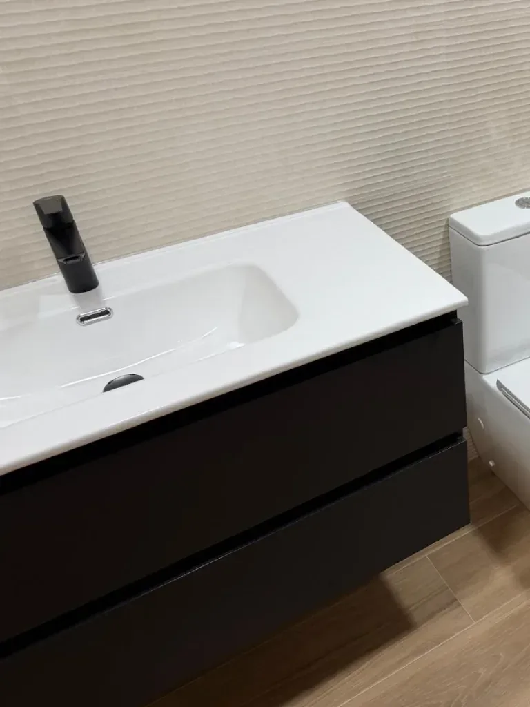Detalle de encimera de lavabo con grifo en negro mate
